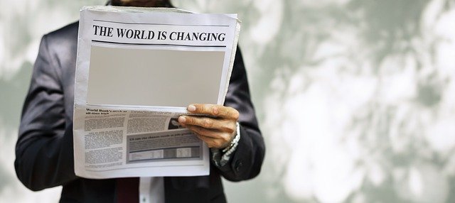 A businessman stands reading a traditional publishers newspaper and on the reverse the print heading reads 'the world is changing'. Even newspapers must become inclusive.