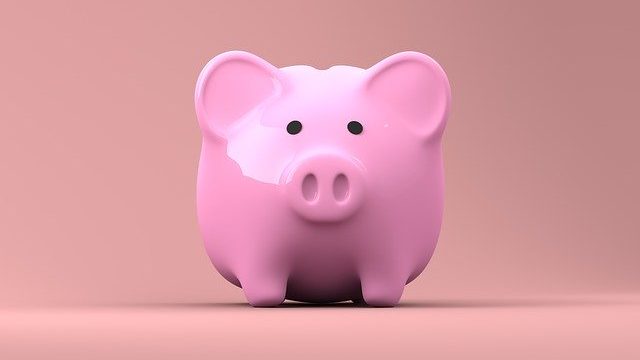 A piggy bank sits on a table top to indicate money being at the heart of business decisions. Traditional publishers must be sold the idea of accessibility because it will cost them money.